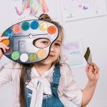 Niña con paleta de colores y pincel